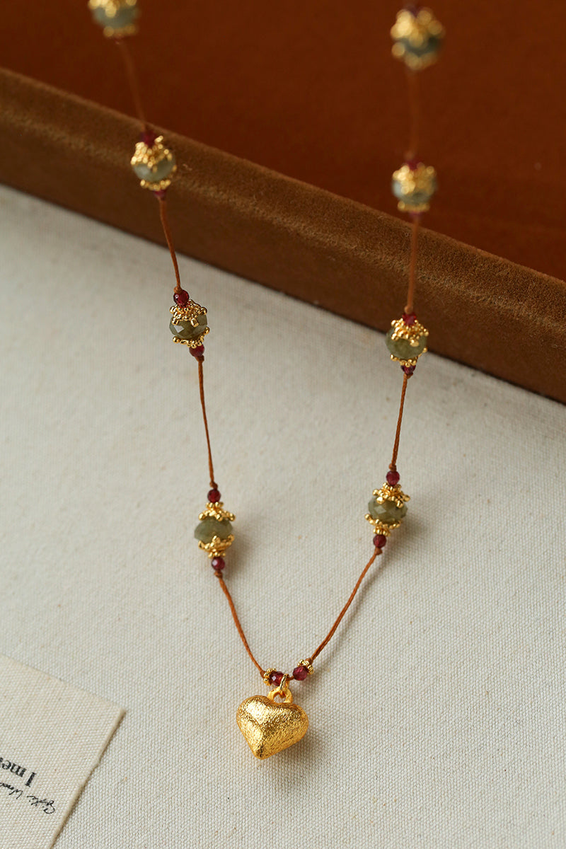 Labradorite and garnet necklace hanging from a display
