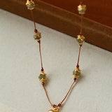 Labradorite and garnet necklace hanging from a display