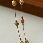 Close-up of gemstone stations on brown cord