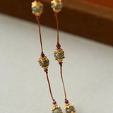 Close-up of gemstone stations on brown cord