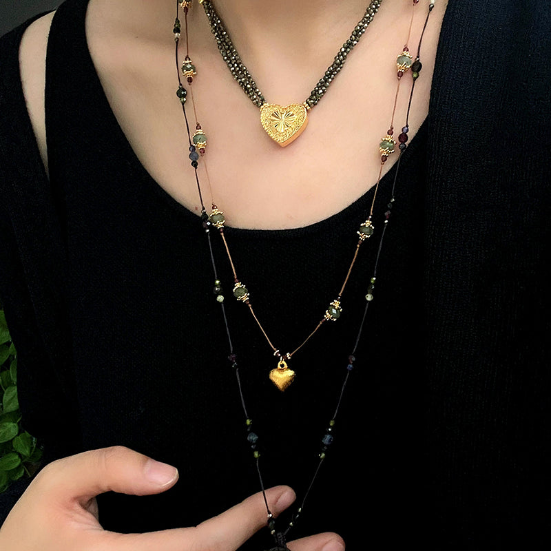 Heart pendant cord necklace layered over a black top