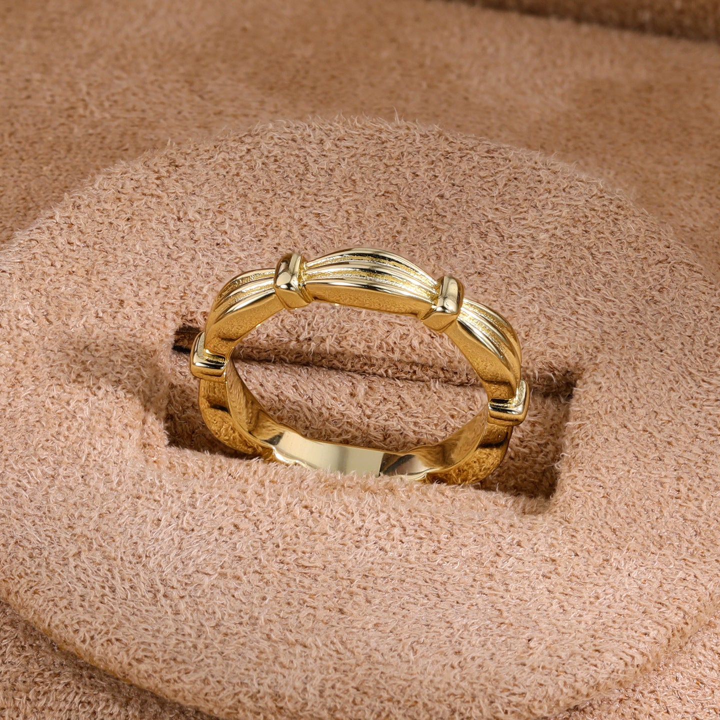 Gold ribbon-inspired band ring on display