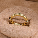 Gold ribbon-inspired band ring on display