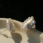 Side view of elongated baroque pearl earrings showing posts and pearl accents