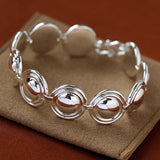 Silver oval dome bracelet on a brown display