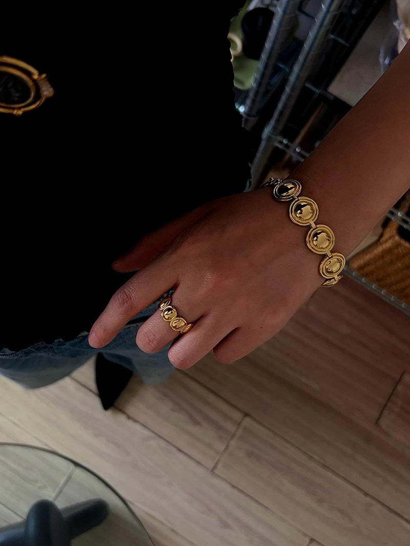 Gold oval dome bracelet worn with matching rings