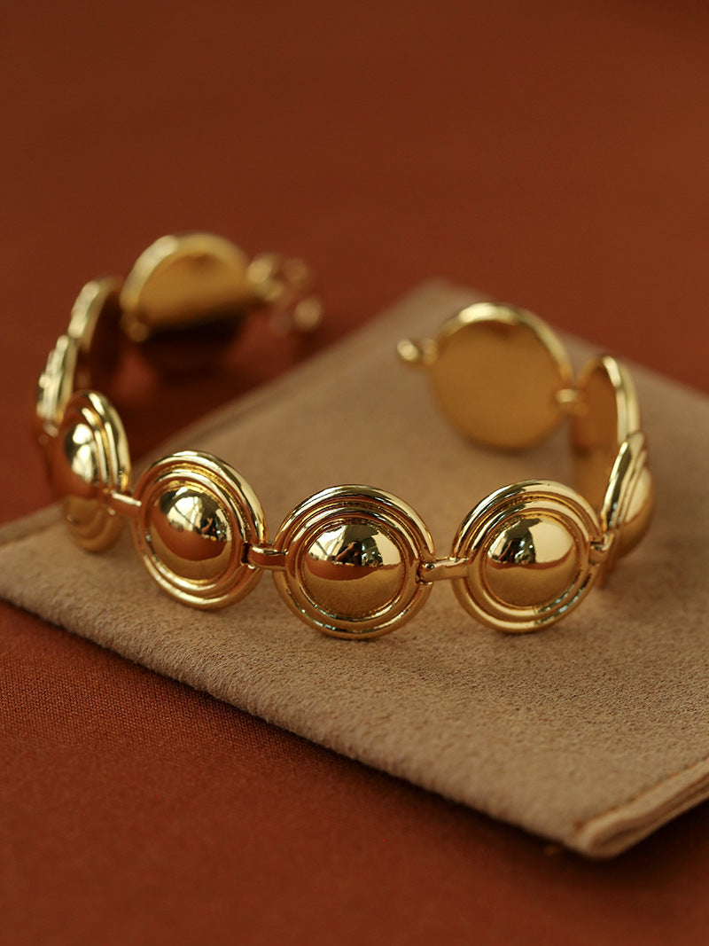 Gold oval dome bracelet on a brown display