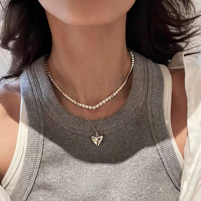 Tennis necklace layered with a heart pendant necklace