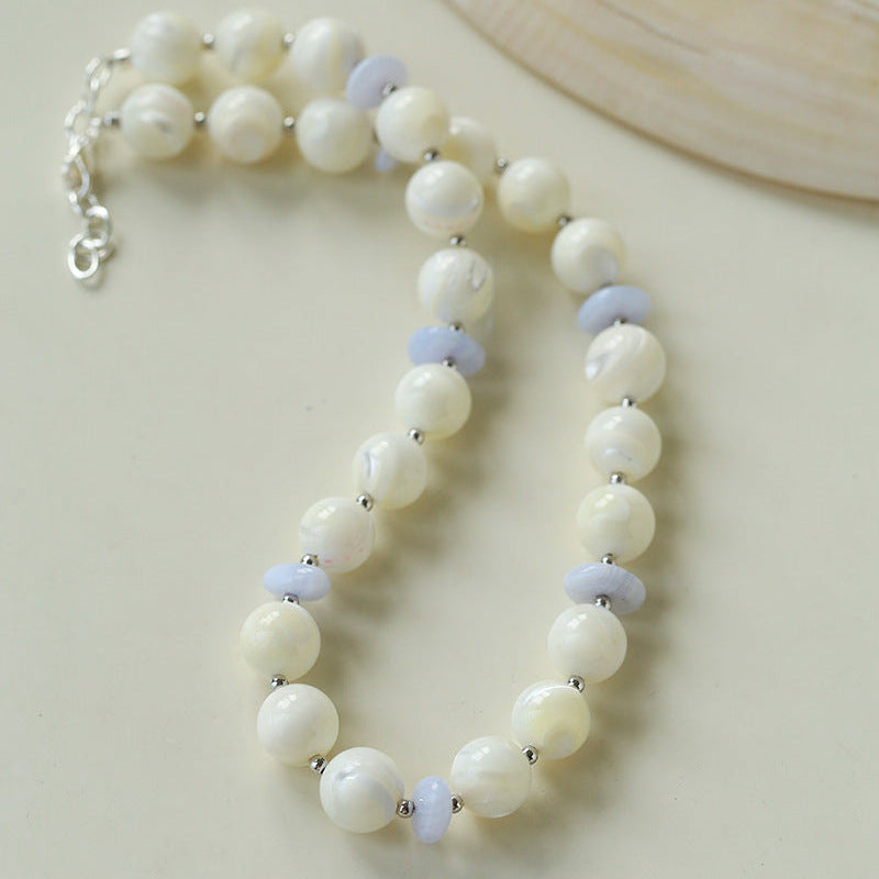 Pearl bracelet with small blue beads on a light background