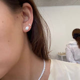 Close-up of silver tennis necklace at the neckline