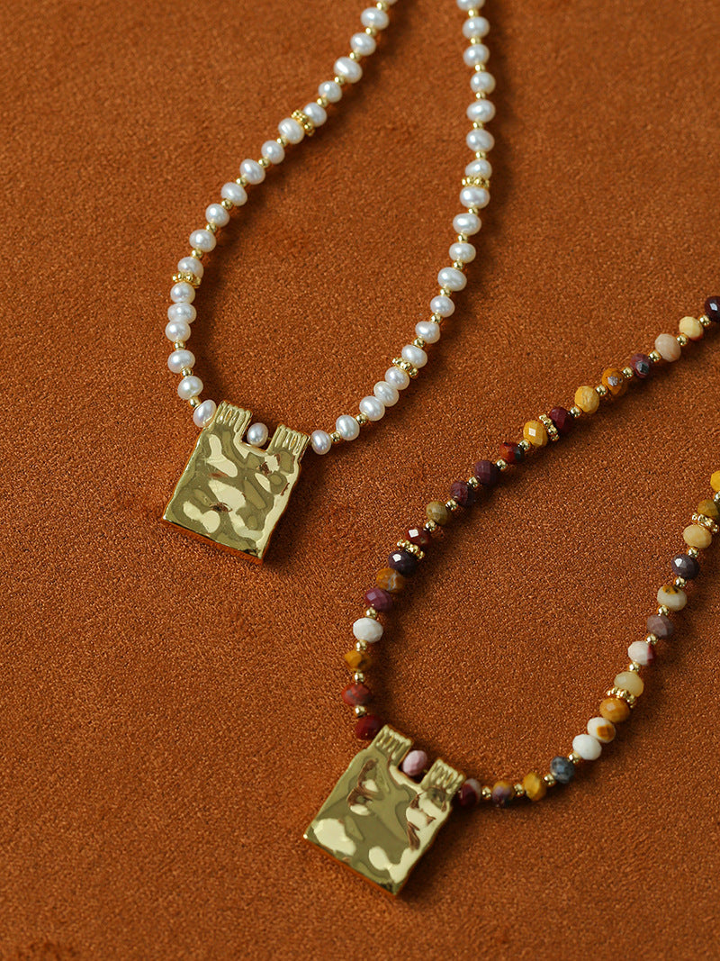 Pearl and stone necklace pendants shown together