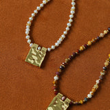 Pearl and stone necklace pendants shown together