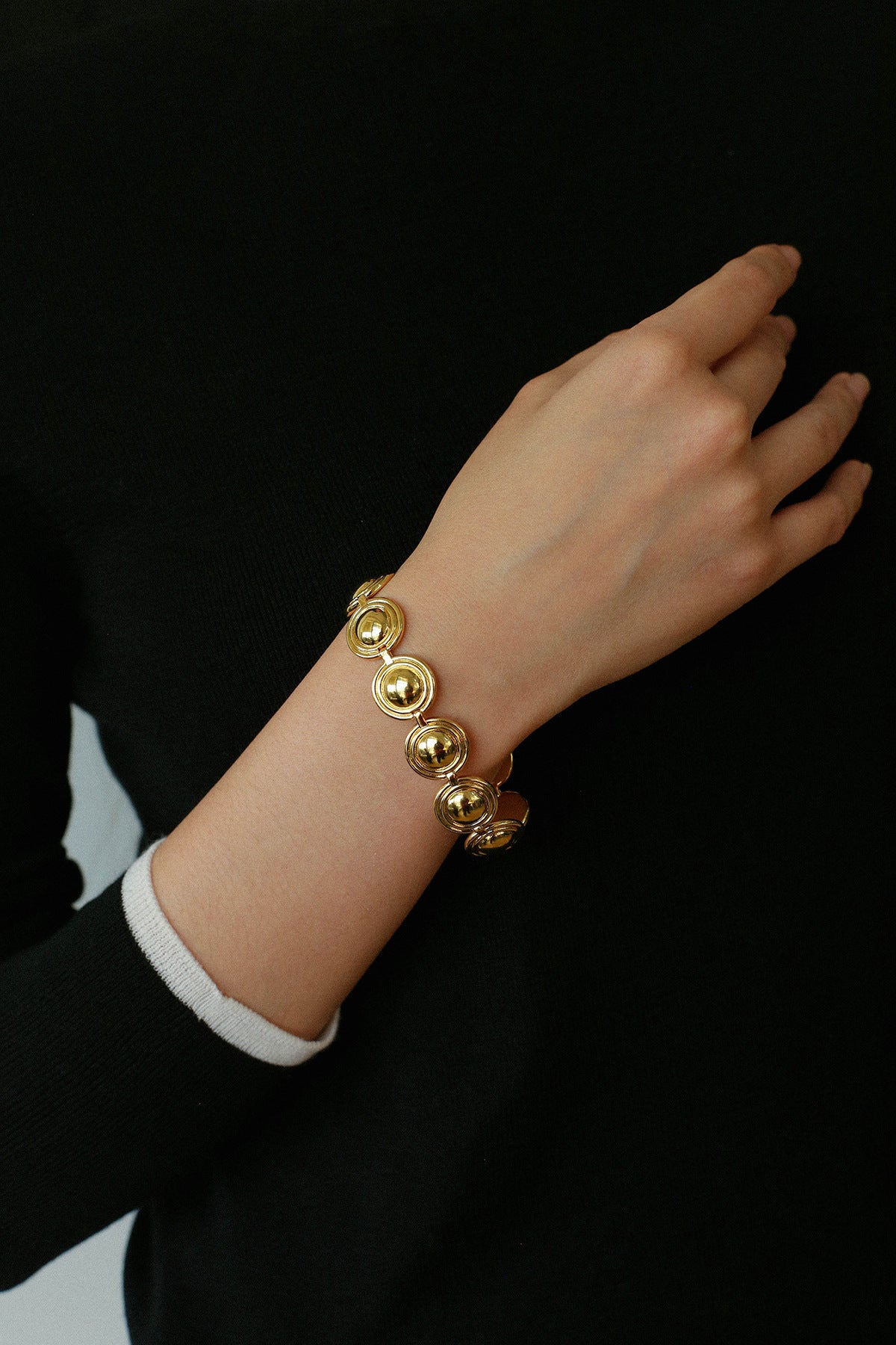 Gold oval dome link bracelet worn on the wrist