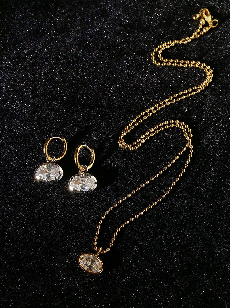 Coordinating oval cubic zirconia earrings and long gold-tone pendant necklace