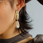 Gold Molten Landscape pearl earrings worn on the ear