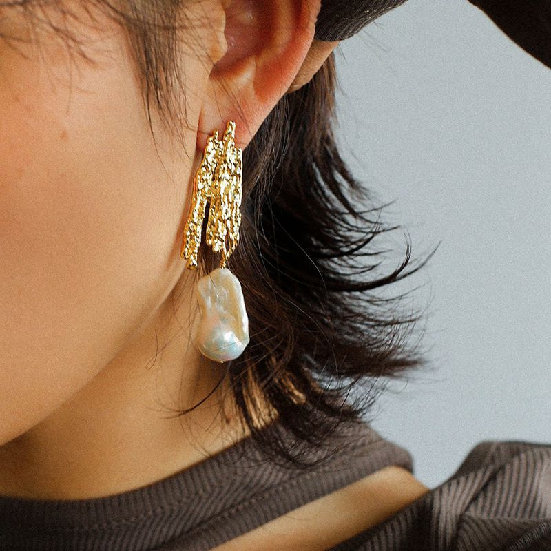 Gold Molten Landscape pearl earrings worn on the ear