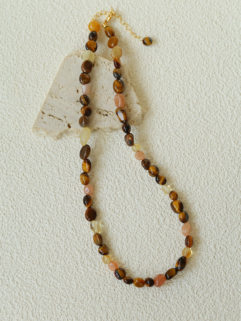 Full-length caramel natural stone necklace on a cream textured display