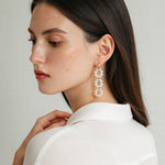 Side view of a model wearing cascading freshwater pearl hoop earrings