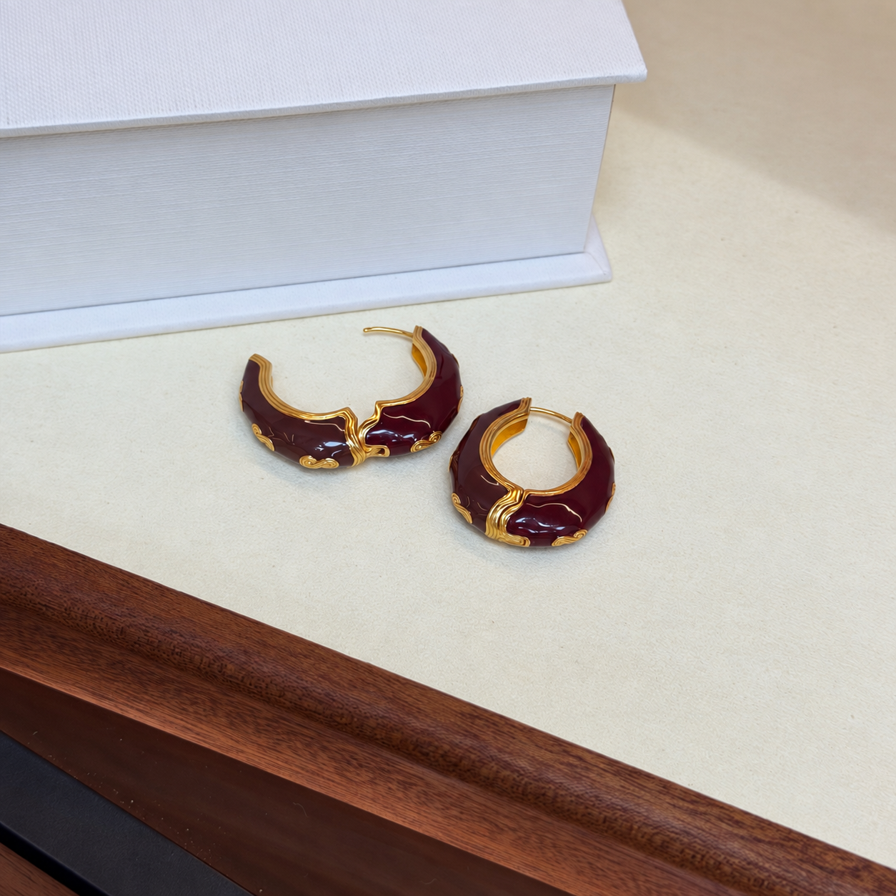 Burgundy enamel hoop earrings with hinged closure open