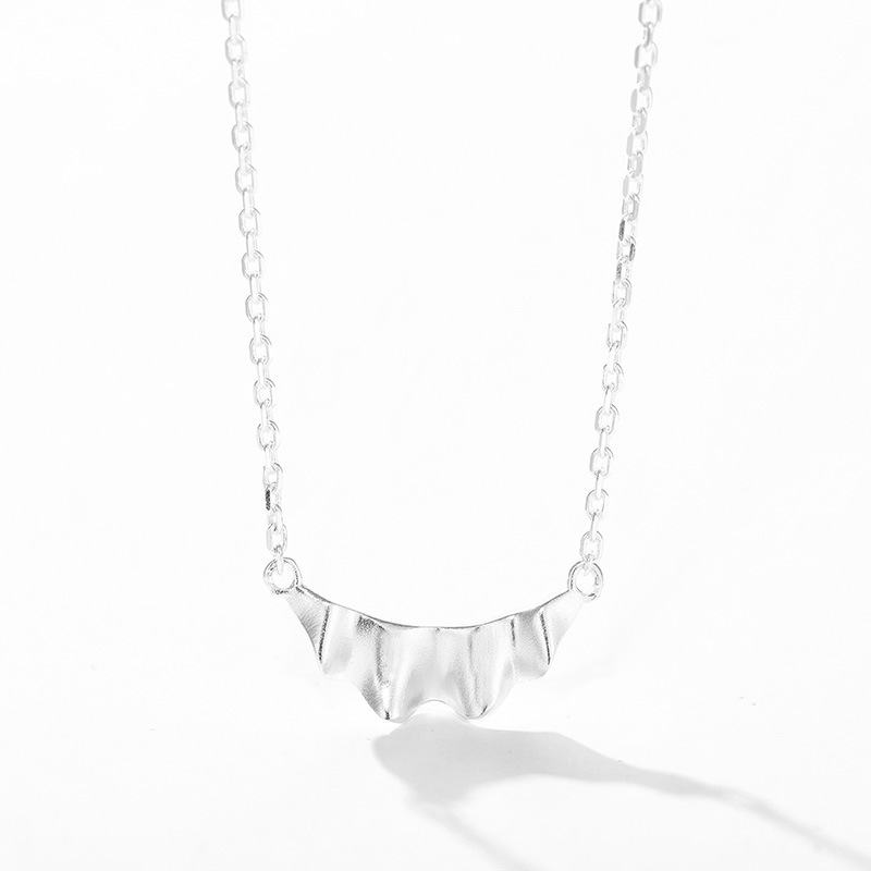 Silver ruffle pendant and chain on white background