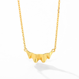 Gold ruffle pendant and chain on white background