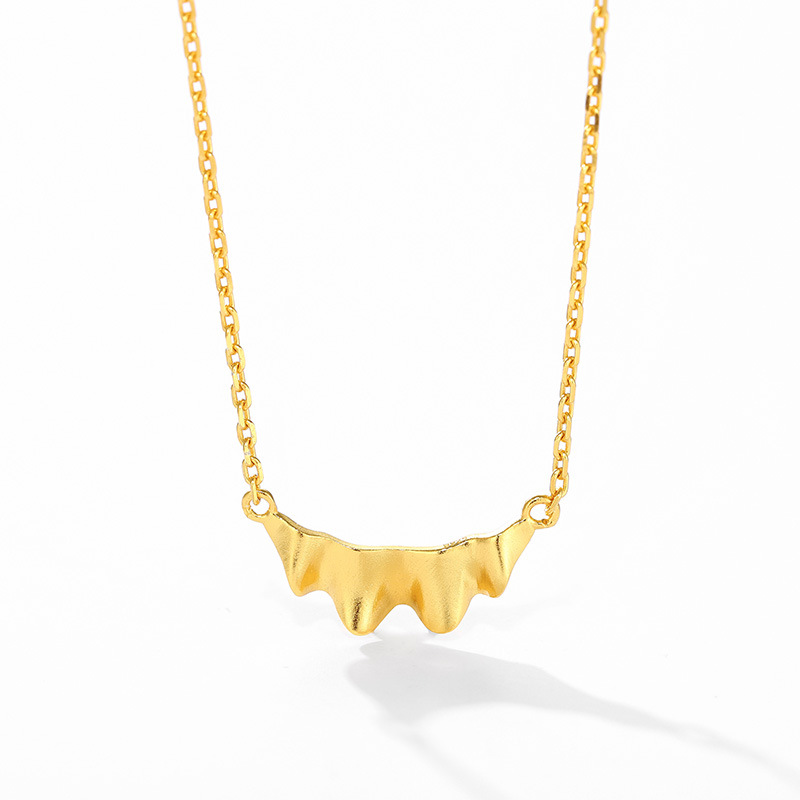 Gold ruffle pendant and chain on white background