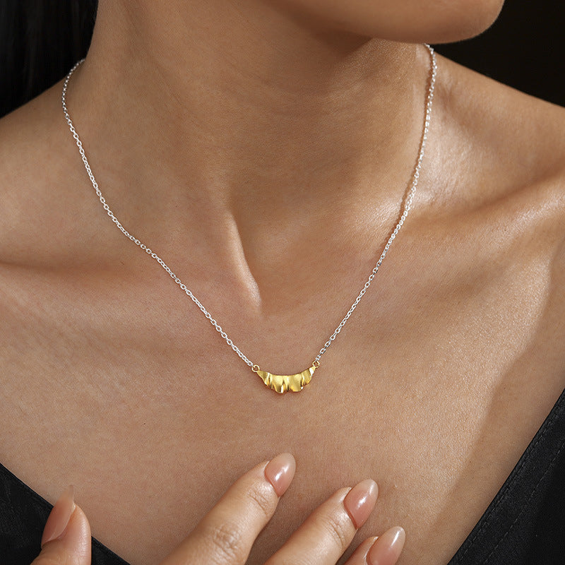 Two-tone ruffle pendant necklace worn at the neckline