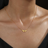 Gold ruffle pendant necklace worn at the neckline