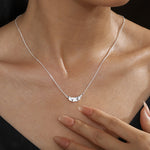 Silver ruffle pendant necklace worn at the neckline