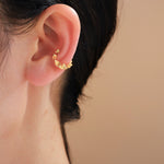 Gold ruffle ear cuff worn on the ear