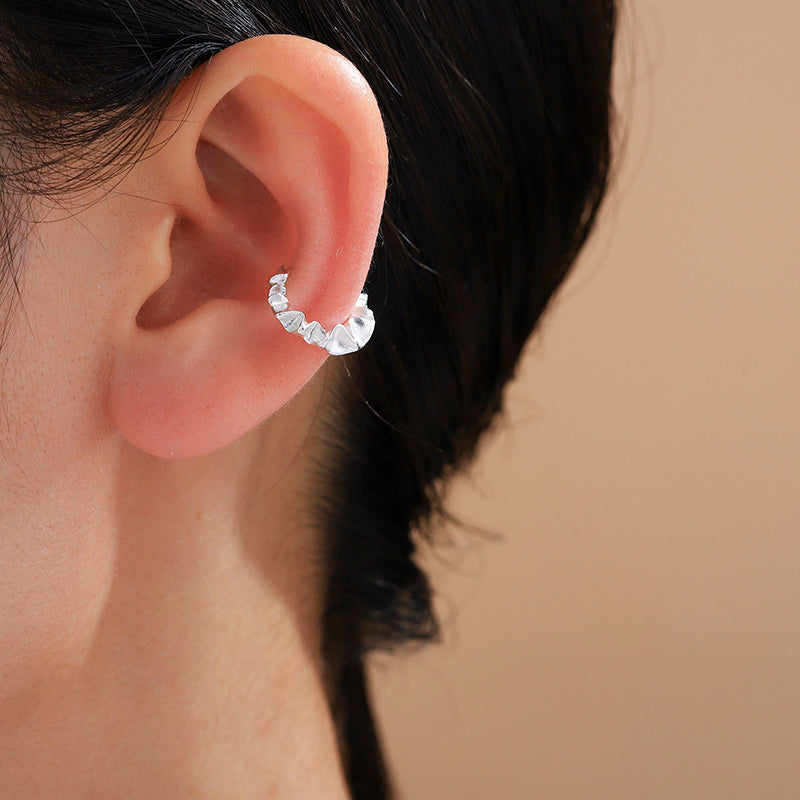 Silver ruffle ear cuff worn on the ear