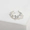 Silver sculptural ruffle ear cuff on a white display