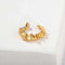 Gold sculptural ruffle ear cuff on a white display