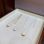 Three finishes of ruffle necklaces in a jewellery tray