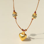 Close-up of gold heart pendant and gemstone stations