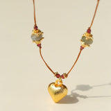 Close-up of gold heart pendant and gemstone stations
