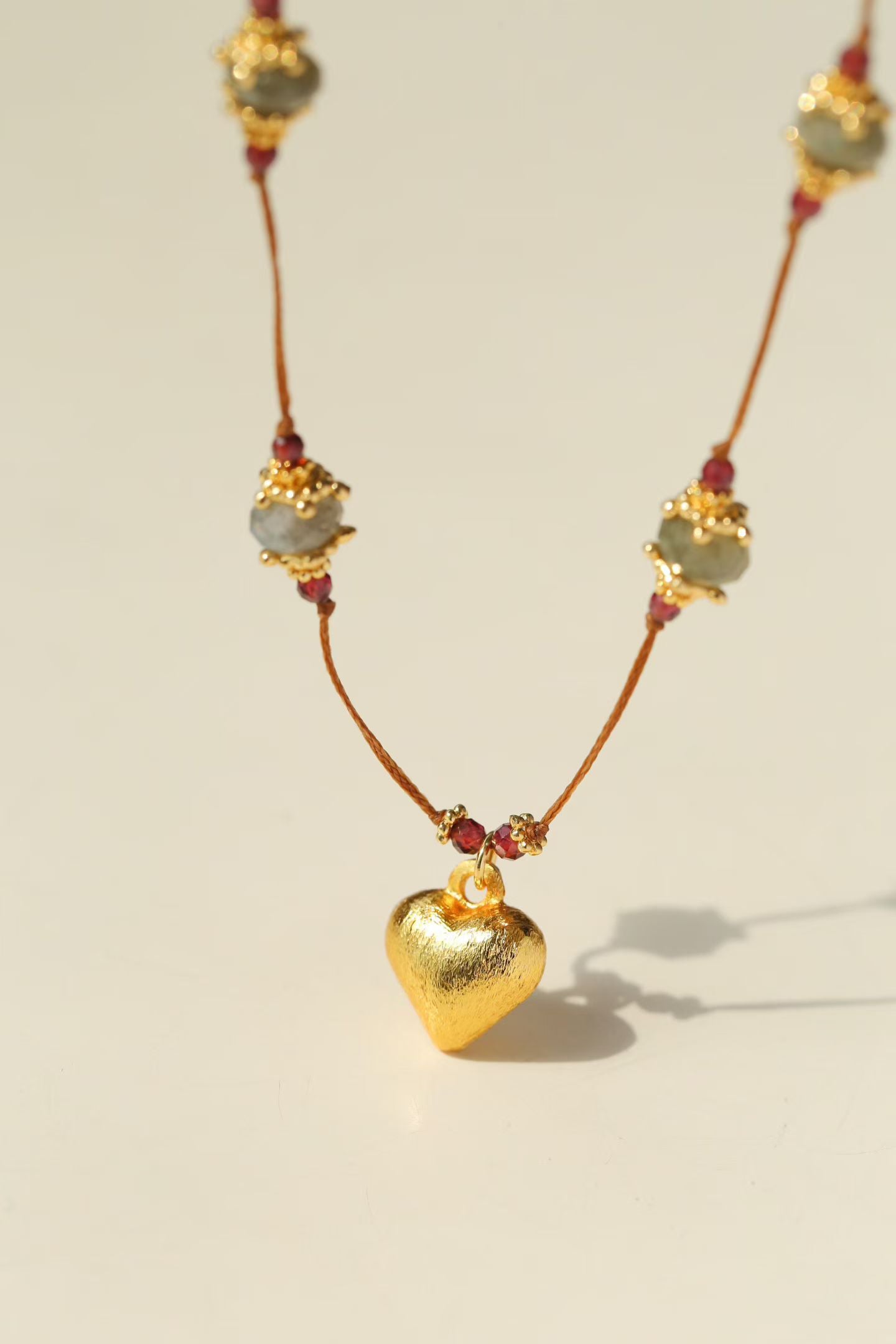 Close-up of gold heart pendant and gemstone stations