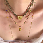 Gold heart pendant necklace in a layered neckline