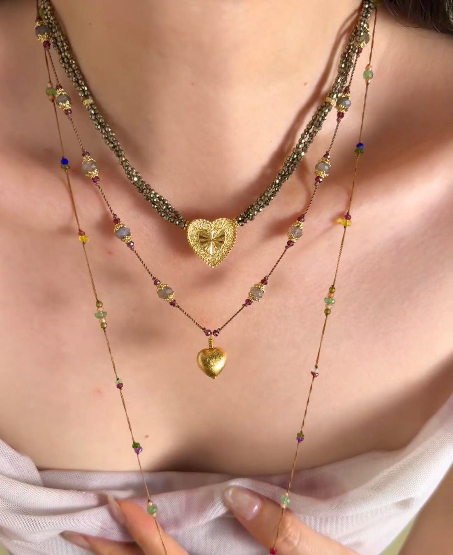 Gold heart pendant necklace in a layered neckline
