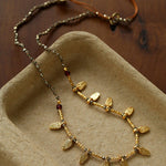 Close-up of faceted pyrite beads and textured leaf charms