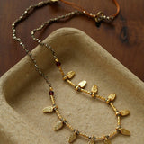 Close-up of faceted pyrite beads and textured leaf charms