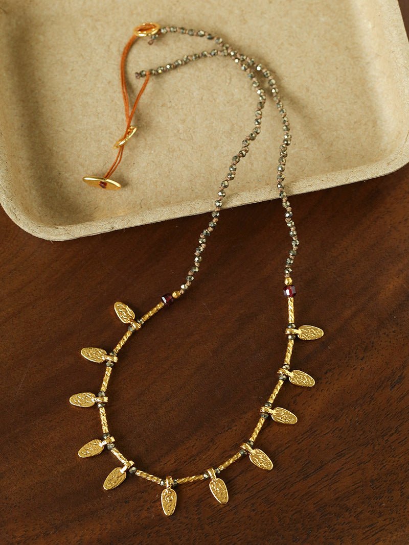 Hand-strung pyrite necklace with hammered gold leaf charms