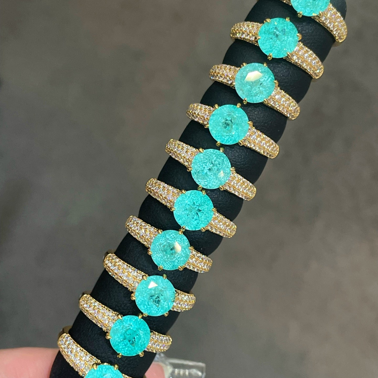 Blue-green round gemstone rings with pavé-set gold bands