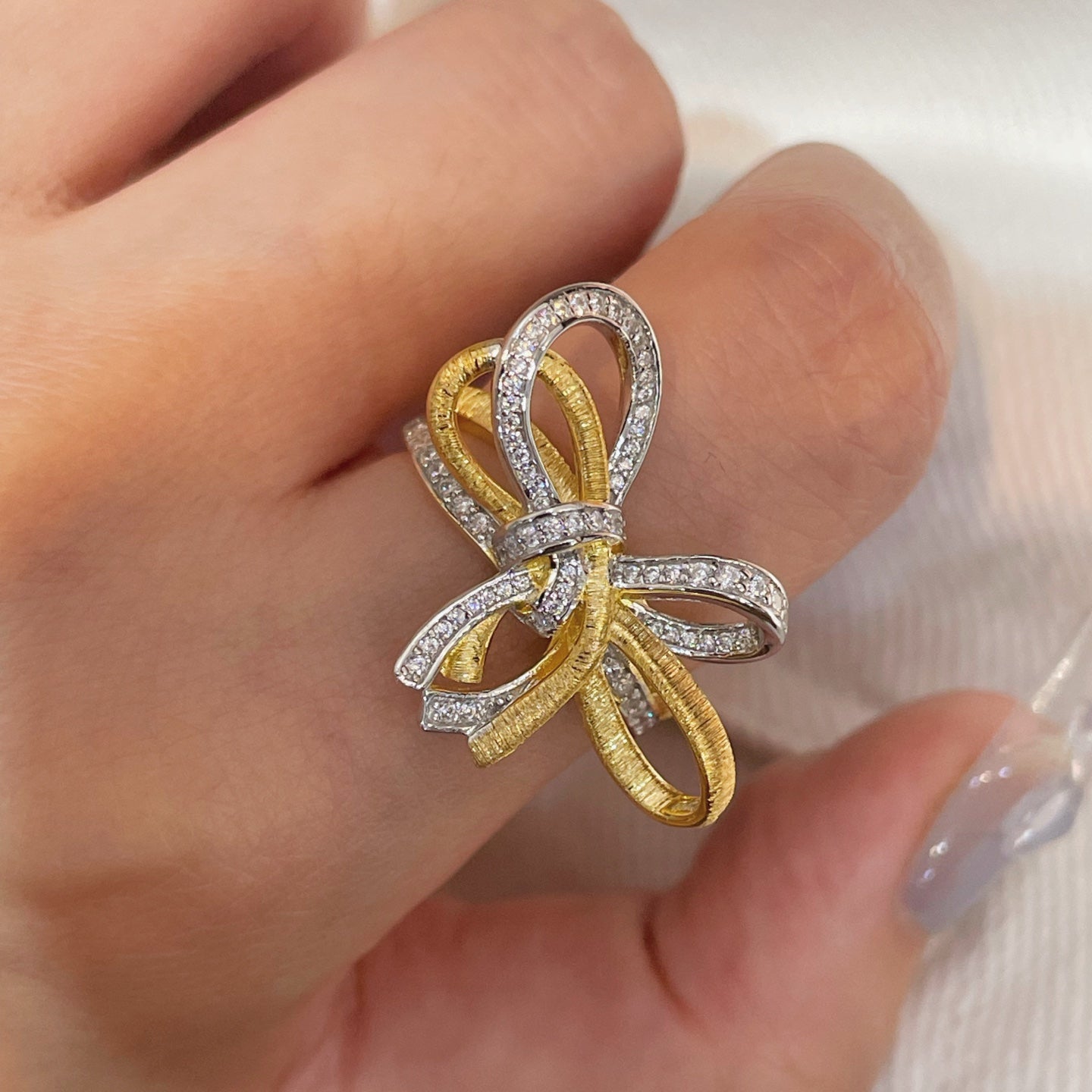Sculptural gold and silver bow ring with sparkling simulants