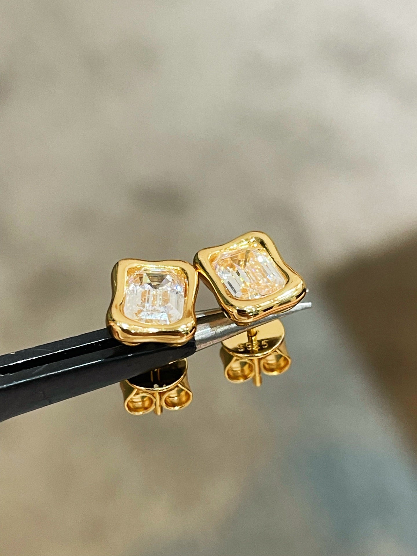 Close-up of clear rectangular stones in irregular gold frames