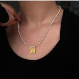 Freshwater pearl square pendant necklace worn at the neckline